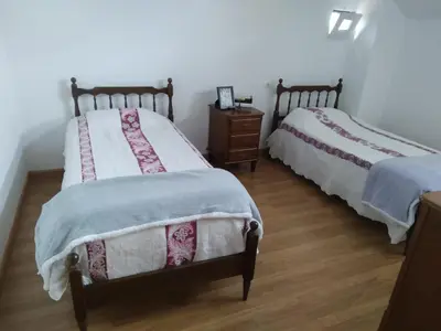 a bedroom with two beds and a wooden floor at Ático Rosita en Camino de Santiago in Xinzo de Limia