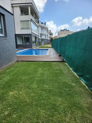 a fence next to a building with a swimming pool at Apartamento de playa familiar, piscina y garaje. in Ares