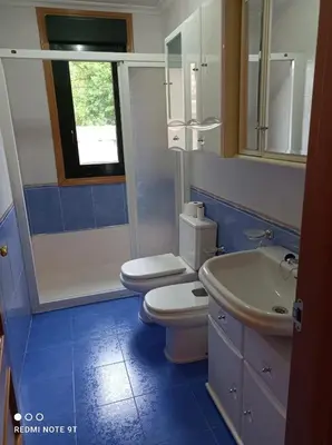a bathroom with a toilet and a sink and a mirror at apartamento de dos habitaciones en Quiroga in Quiroga