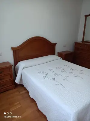 a bedroom with a white bed and two dressers at apartamento de dos habitaciones en Quiroga in Quiroga