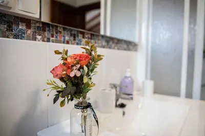 a vase of flowers sitting on a sink in a bathroom at El balcón de la Penela in Belesar