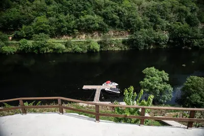 a boat on a river next to a wooden bridge at El balcón de la Penela in Belesar