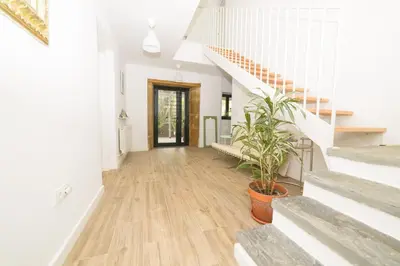 a hallway of a home with stairs and a potted plant at Apartamentos turísticos Praia de Seselle, terraza y jardín a un paso de la playa in Ares