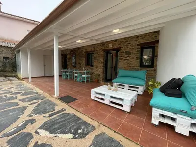 a patio with two couches and a table and chairs at Apartamentos turísticos Praia de Seselle, terraza y jardín a un paso de la playa in Ares