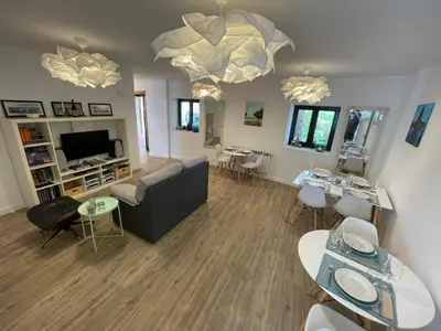 a living room with a couch and tables and a television at Apartamentos turísticos Praia de Seselle, terraza y jardín a un paso de la playa in Ares