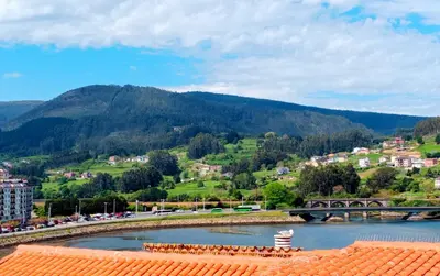 a view of a river with a bridge and a mountain at Atico en La Ría in Vivero
