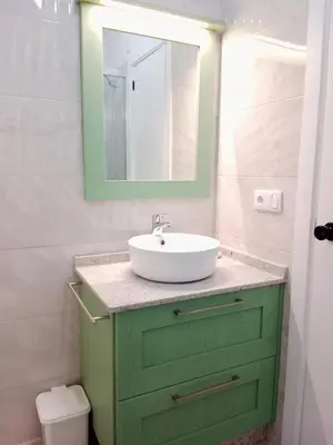 a bathroom with a green cabinet with a sink at Atico en La Ría in Vivero
