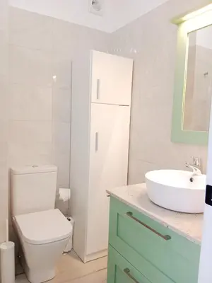 a bathroom with a white toilet and a sink at Atico en La Ría in Vivero