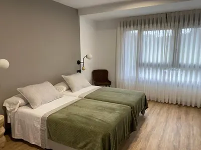 a bedroom with a large bed and a window at Pensión Casa Cancela in Palas de Rei