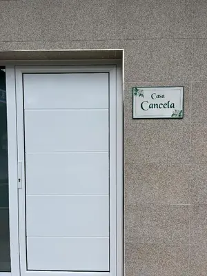 a door to a building with a sign on it at Pensión Casa Cancela in Palas de Rei