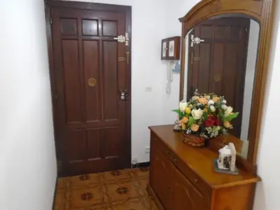 a bathroom with a dresser with a mirror and flowers on it at Piso céntrico Pontedeume in Puentedeume