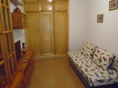 a living room with a couch and a wooden cabinet at Piso céntrico Pontedeume in Puentedeume