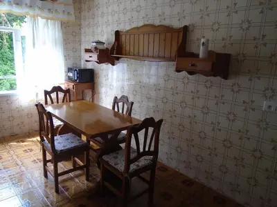 a wooden table and chairs in a room with wallpaper at Piso céntrico Pontedeume in Puentedeume