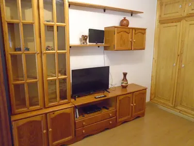 a entertainment center with a television on a wooden cabinet at Piso céntrico Pontedeume in Puentedeume