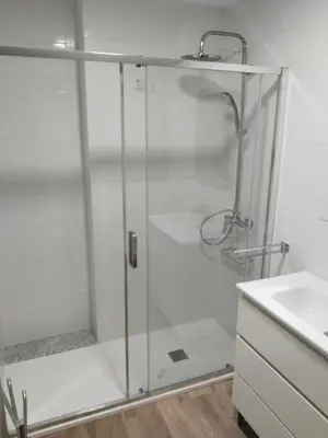 a shower with a glass door next to a sink at Piso céntrico Pontedeume in Puentedeume
