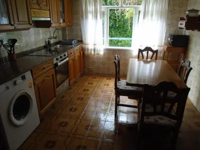 a kitchen with a table and a sink and a stove at Piso céntrico Pontedeume in Puentedeume