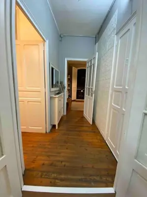 a hallway with two white doors and a wooden floor at O Cerrulo Apartamento céntrico Pontedeume in Puentedeume