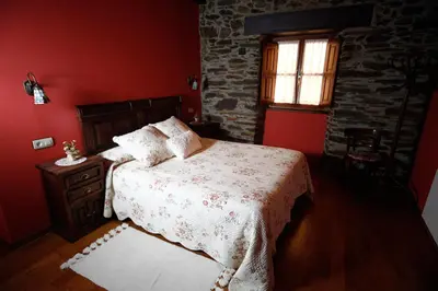 a red bedroom with a bed and a window at Casa Xuaquin in Moal