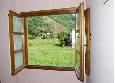 a window in a house with a view of a field at Casa Xuaquin in Moal