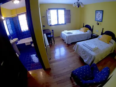 a room with two beds and a bathroom with a tub at Casa Xuaquin in Moal