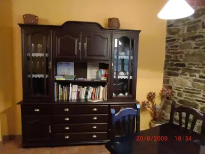 a large wooden cabinet with books in it at Casa Xuaquin in Moal