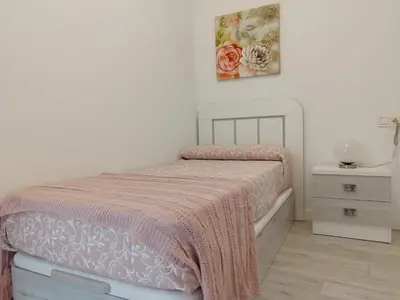 a white bedroom with a bed with a pink blanket at BALCON DEL EO in Ribadeo
