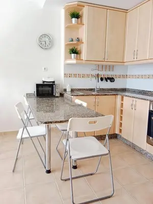 a kitchen with a table and chairs in a room at El Mirador 2 in Vivero