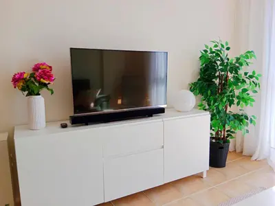 a tv on a white dresser with two plants at El Mirador 2 in Vivero