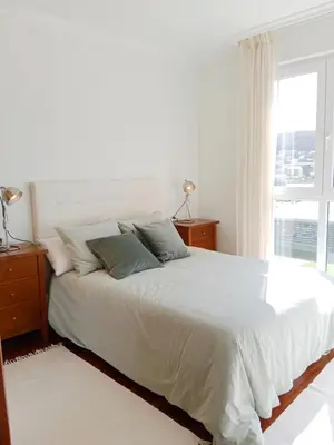 a white bedroom with a large bed and a window at El Mirador 2 in Vivero