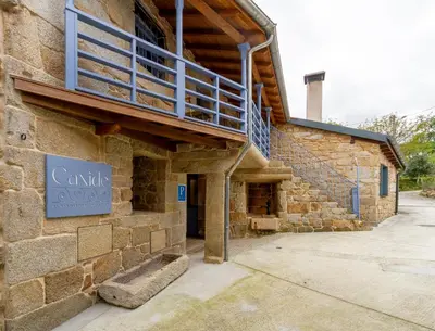 a stone building with a balcony on the side of it at Alojamiento Turístico Caxide Parada de Sil Ribeira Sacra in Parada del Sil