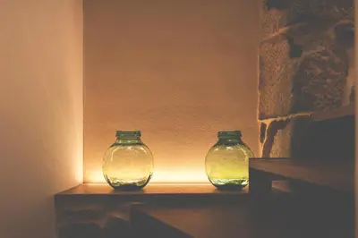 two glass vases sitting on a shelf with a light at Alojamiento Turístico Caxide Parada de Sil Ribeira Sacra in Parada del Sil
