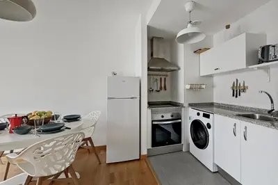 a kitchen with a table and a white refrigerator at Apt. p/4 en la Playa de Viveiro in Viveiro