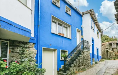 a blue building with a staircase in front of it at 1 Bedroom Stunning Home In Galicia in Belesar