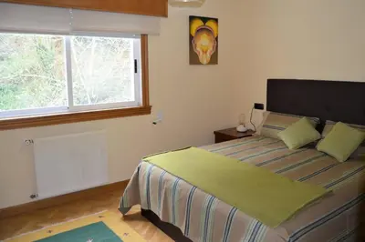 a bedroom with a large bed with a window at Acogedor piso con vistas en Sada in Sada