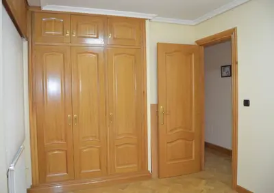a room with two wooden cabinets next to a door at Acogedor piso con vistas en Sada in Sada