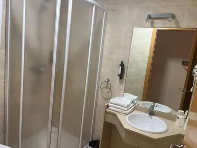 a bathroom with a shower and a sink and a mirror at Apartamento San Bartolo in Barreiros