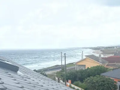 a view of the ocean from the roofs of houses at Apartamento San Bartolo in Barreiros