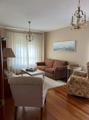 a living room with a couch and a table at Piso con jardín en Ribadeo in Ribadeo
