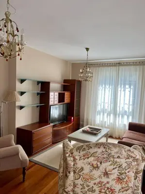 a living room with a couch and a table at Piso con jardín en Ribadeo in Ribadeo