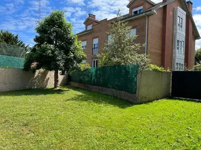 a house with a fence and a tree in a yard at Piso con jardín en Ribadeo in Ribadeo
