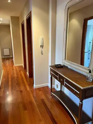 a room with a mirror and a table with a dresser at Piso con jardín en Ribadeo in Ribadeo