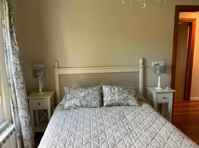 a bedroom with a bed with two night stands and two lamps at Piso con jardín en Ribadeo in Ribadeo