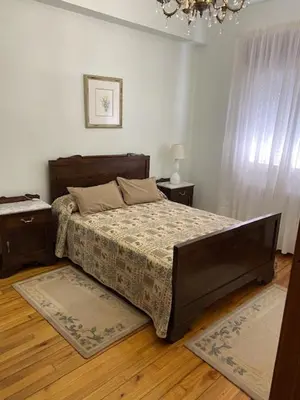 a bedroom with a large bed and a chandelier at Casa Roque in Monforte de Lemos