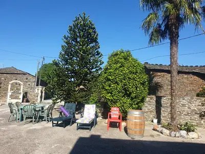 a group of chairs and tables and a tree and a barrel at ANAMAR in Lugo