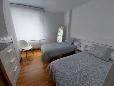 a small room with two beds and a chair at Adiva Praia Miño in Miño