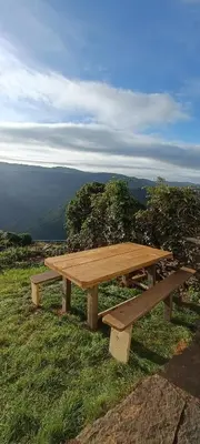 a wooden picnic table sitting on top of a hill at Apartamentos Rurales San Esteban de los Buitres - Illano in San Esteban
