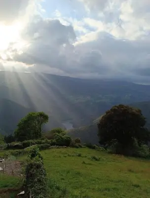 a view of a valley with the sun shining through the clouds at Apartamentos Rurales San Esteban de los Buitres - Illano in San Esteban