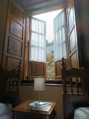 a lamp on a table in front of a window at Apartamentos Rurales San Esteban de los Buitres - Illano in San Esteban