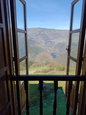 an open window with a view of a mountain at Apartamentos Rurales San Esteban de los Buitres - Illano in San Esteban