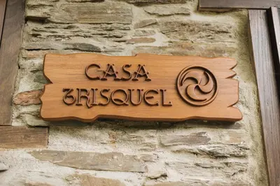 a sign on the side of a stone wall at CASA TRISQUEL in Hospital